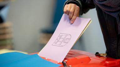 Eine Frau wirft bei der Bürgerschaftswahl 2020 in Hamburg ihre Stimmzettel für die in die Wahlurne. 